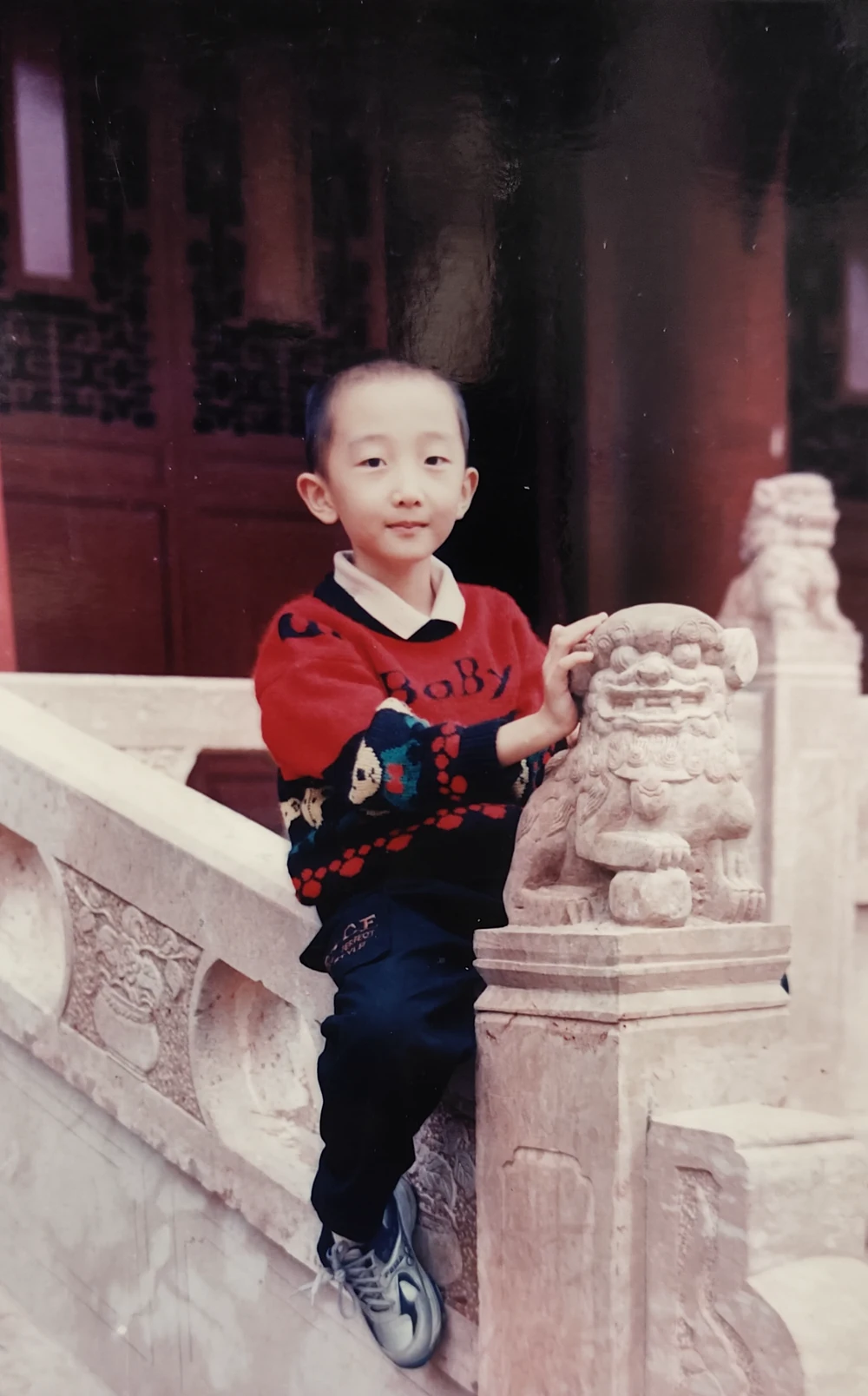 小时候活泼可爱的 Henry 与石狮合影